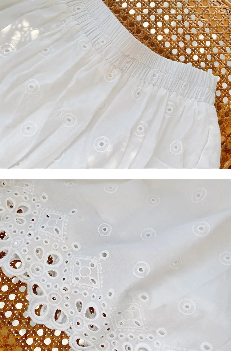 Close-up of white fabric with intricate cut-out pattern on a textured surface