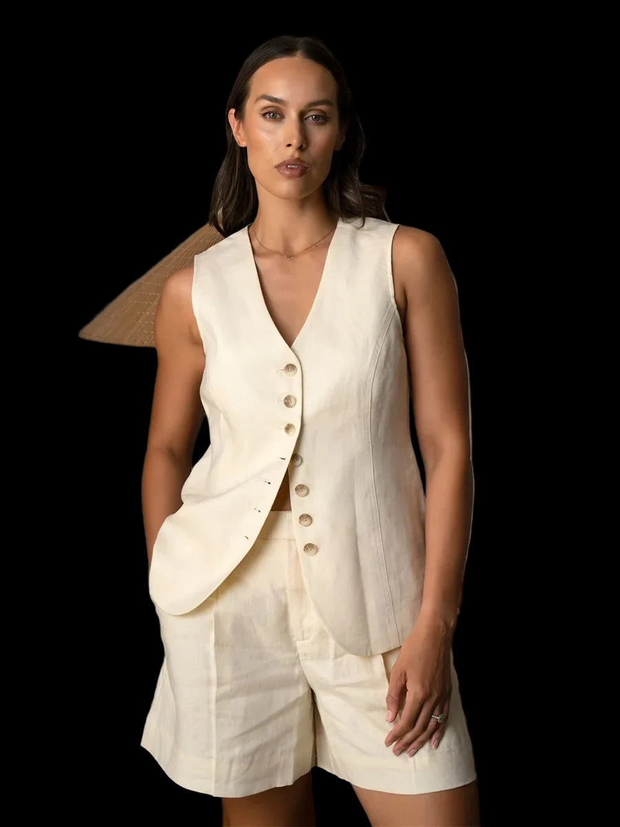 Woman wearing a white sleeveless vest and shorts against black background