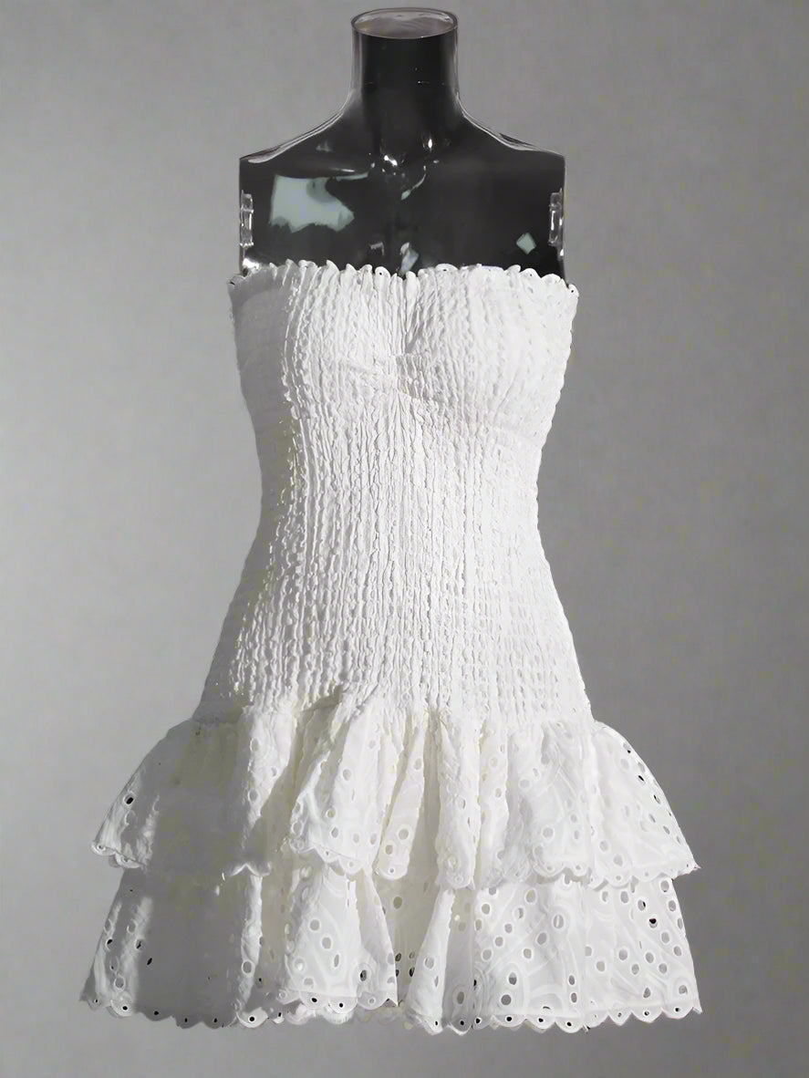 White strapless dress with ruffled layers on a mannequin against a Plain background