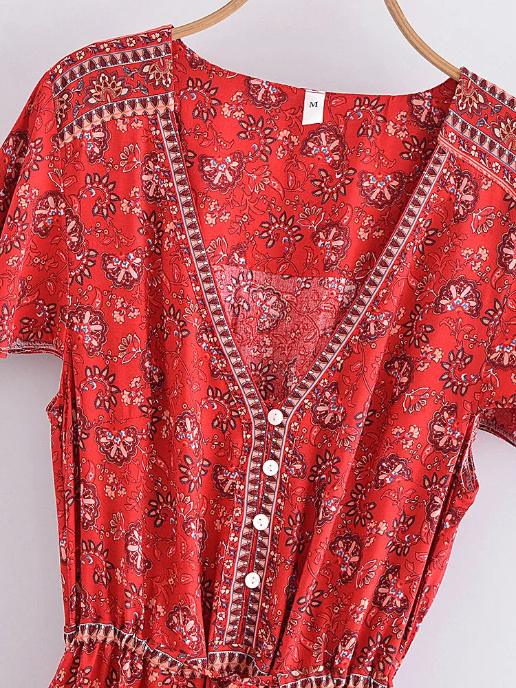 Red patterned dress on a hanger against a white background