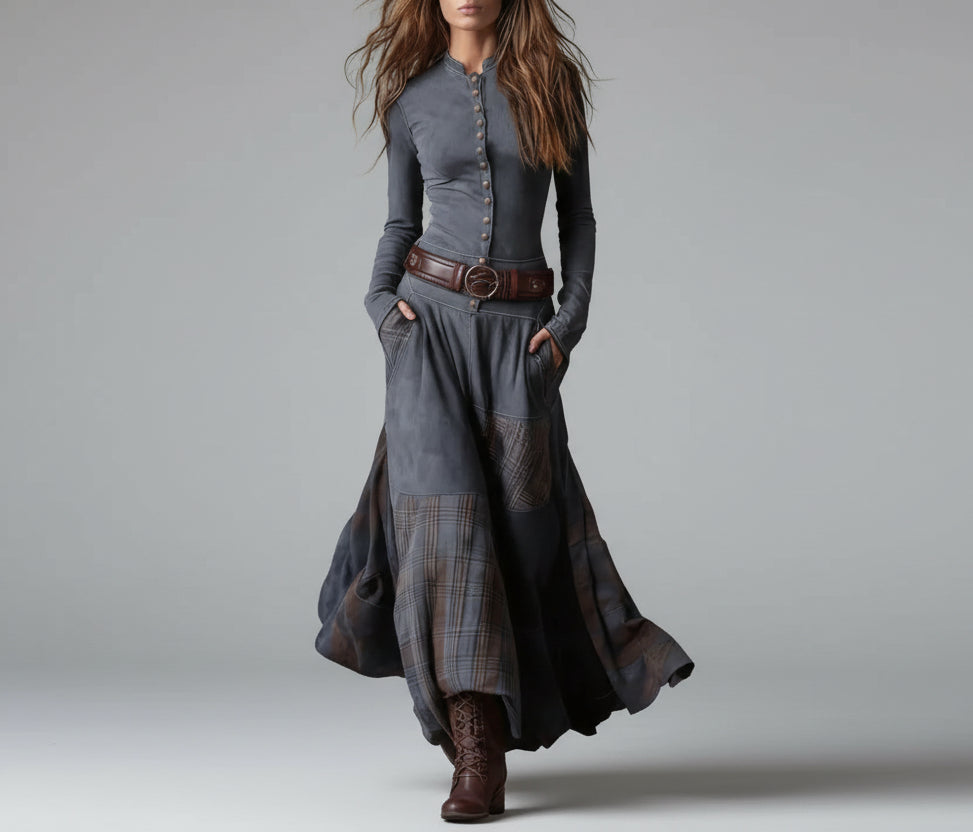 Person wearing a long, dark gray dress with plaid patterns against a neutral background