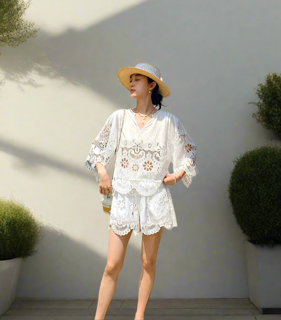 Woman in a white lace outfit standing in a backyard garden, sunny