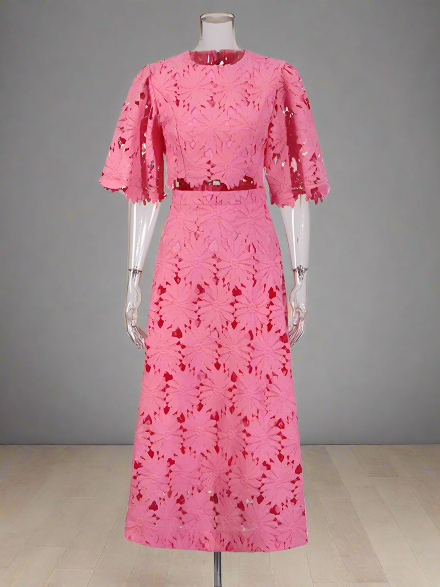 Pink lace dress on a mannequin against a white background