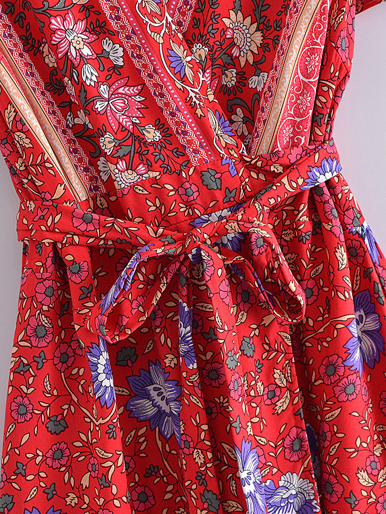 Red floral patterned dress with a belt on a plain background