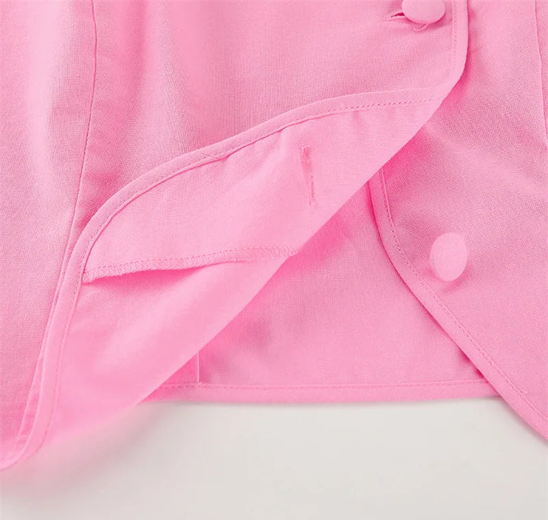 Close-up of a pink garment with buttons on a light gray background