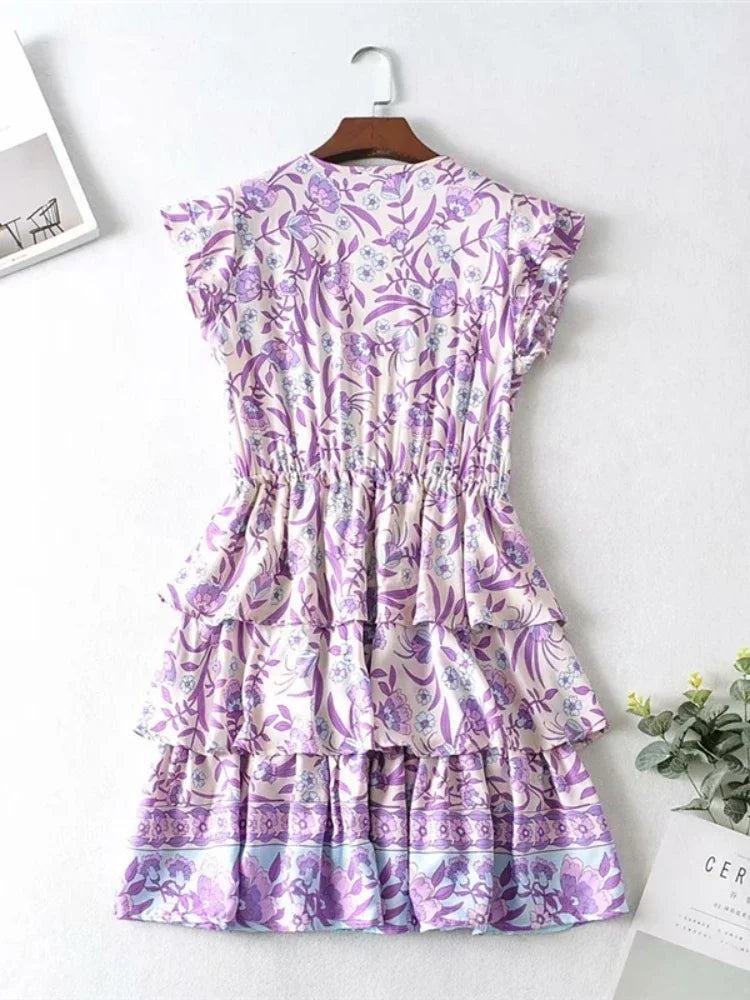 Purple floral dress on a hanger with a white background