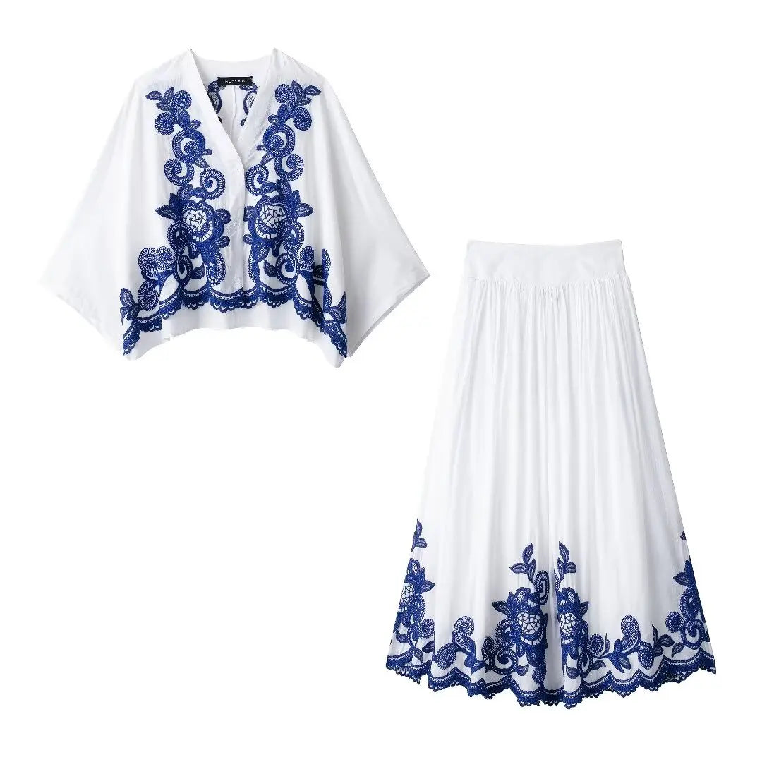 White outfit with blue floral embroidery on a white background
