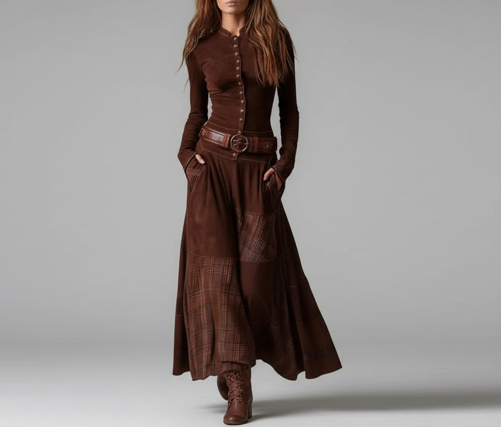 Woman wearing a long brown dress with a belt against a gray background