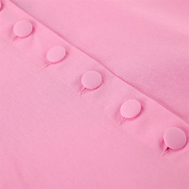 Pink fabric with small pink balloons attached, on a matching pink background