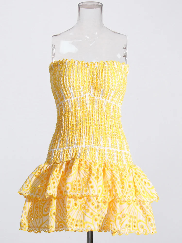 Yellow strapless dress on a mannequin against a white background