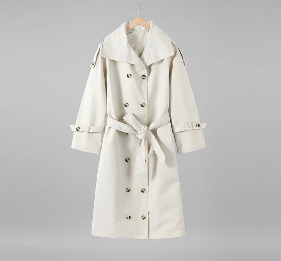 White trench coat on a hanger against a neutral background