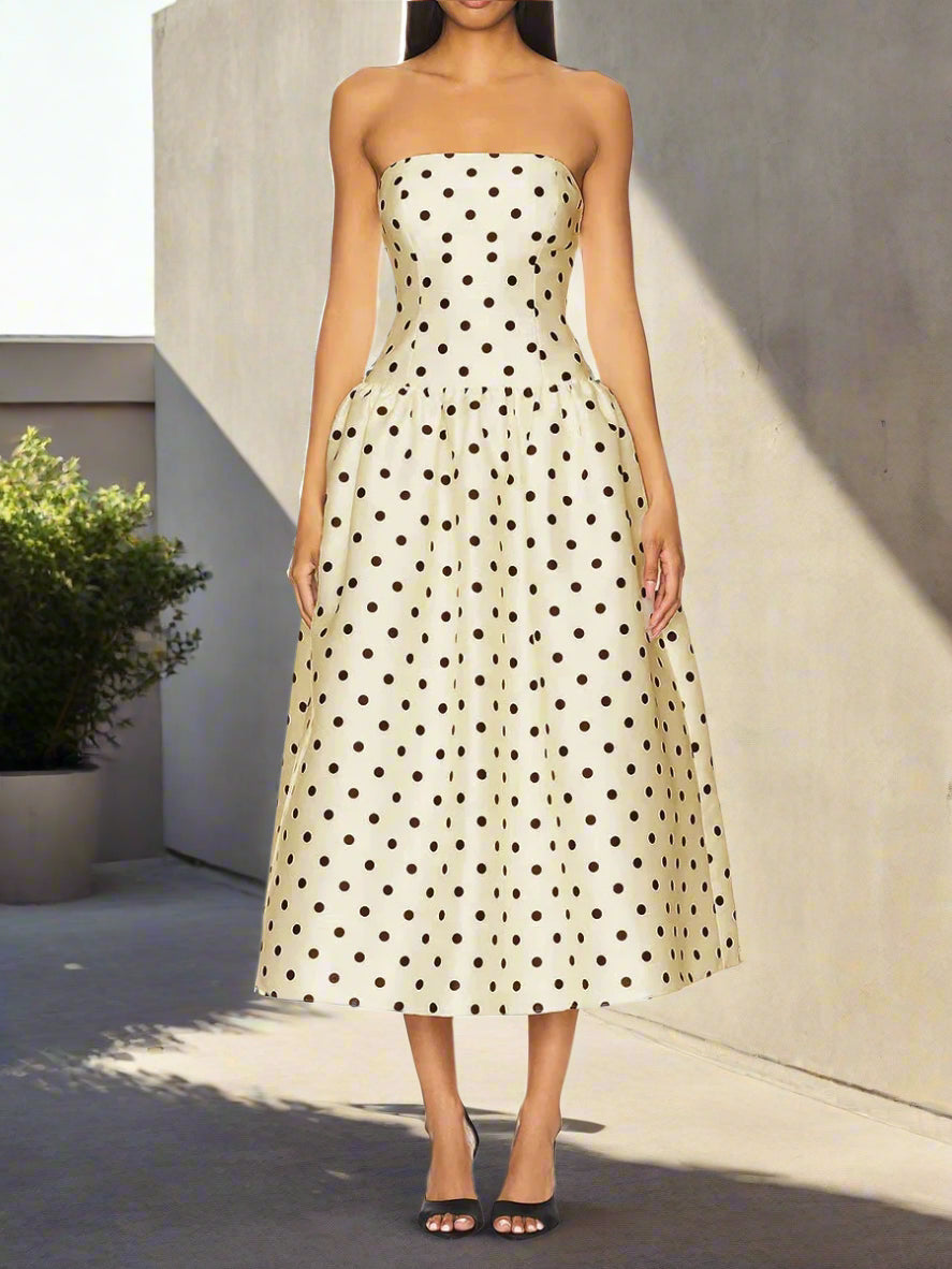 Woman wearing a strapless polka dot dress on a backyard and sunlight