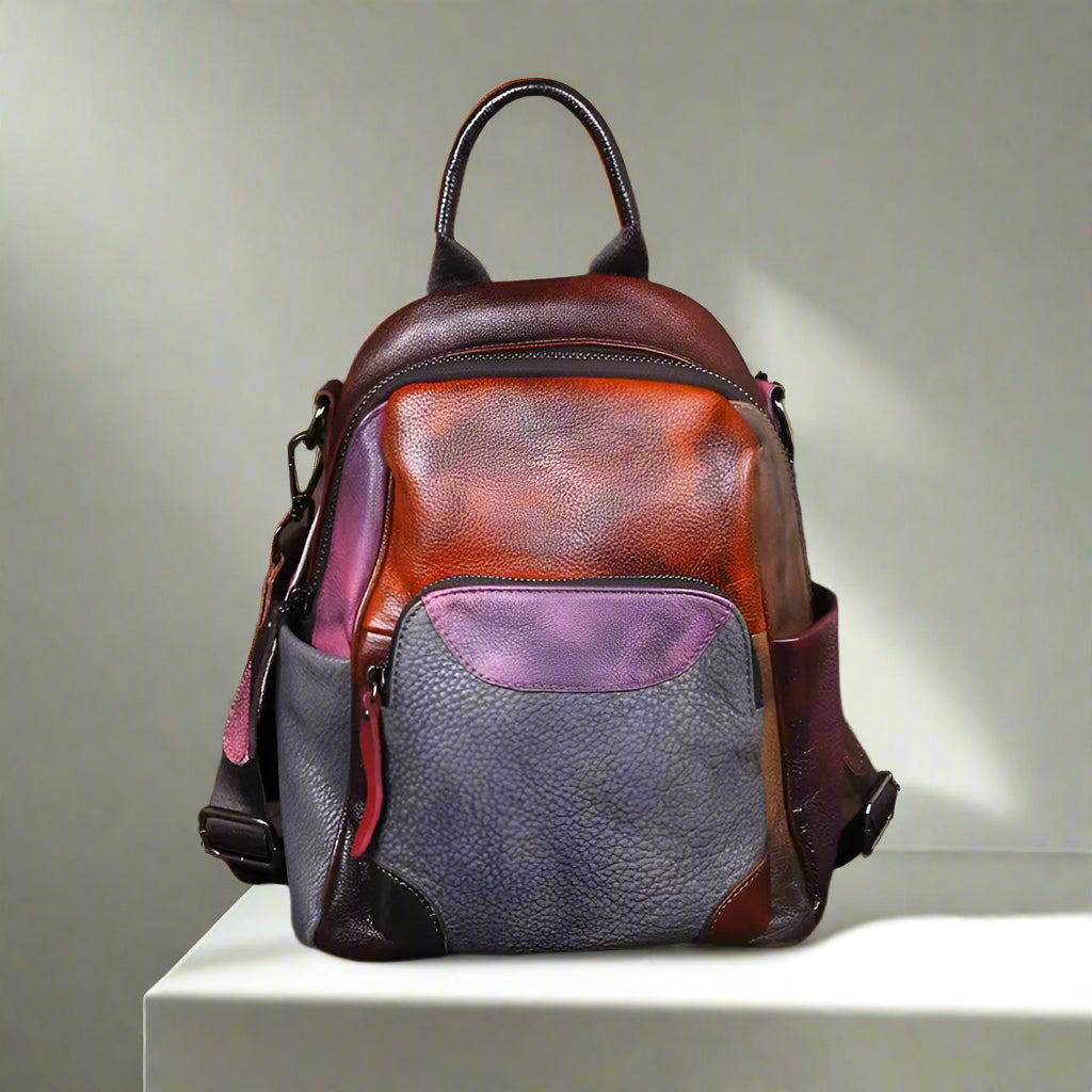 Multicolored leather backpack on a white table with a white wall background
