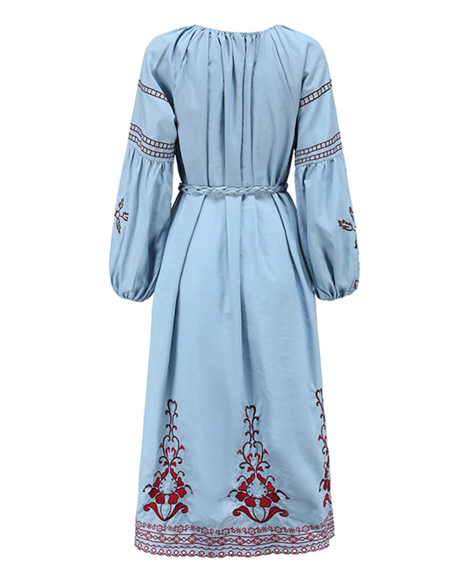 Light blue dress with red and white embroidery on a white background