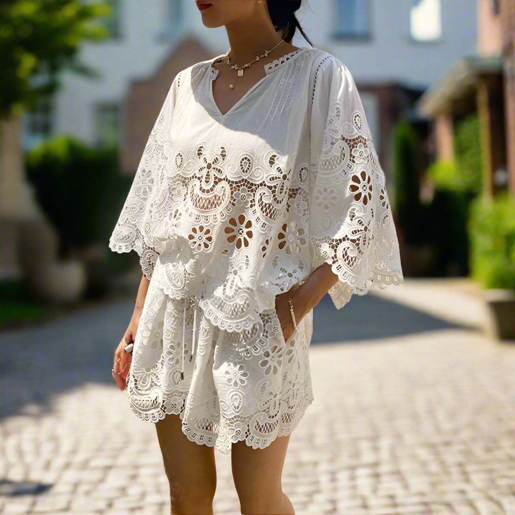 Woman wearing a white lace dress standing in a backyard garden, sunny