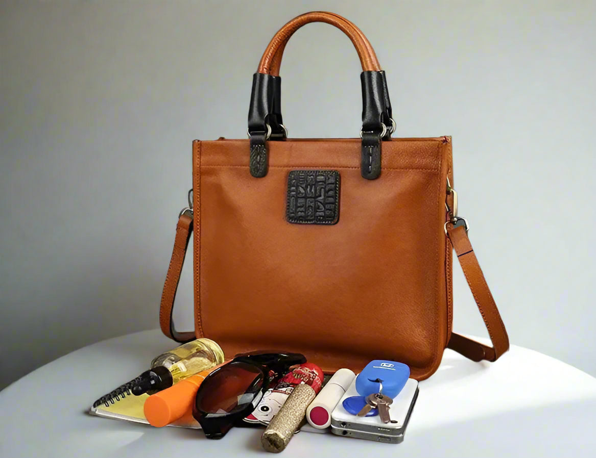 Brown handbag with black accents on a gray background