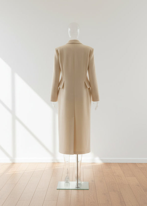 light color coat on a mannequin in an empty room 