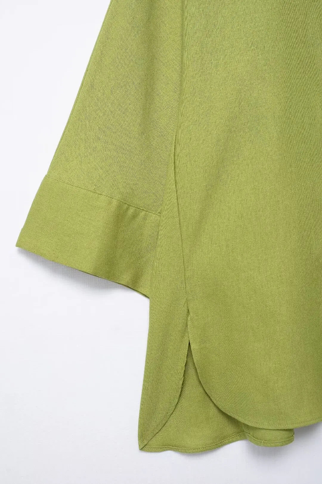 Green fabric with a draped edge on a white background