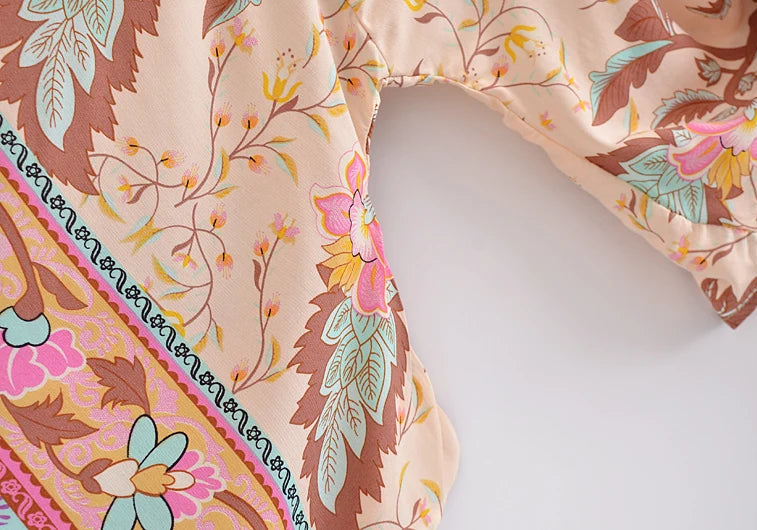 Floral-patterned fabric with pink, brown, and green colors on a white background