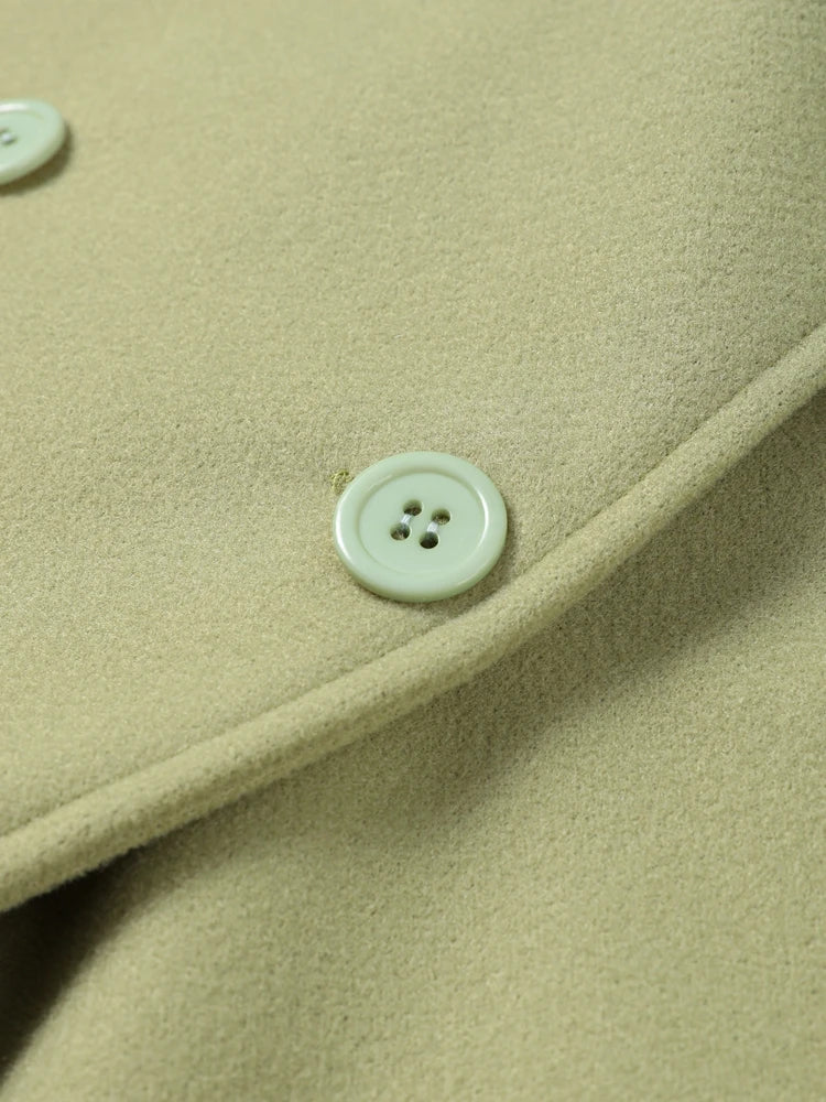 Close-up of a light green button on a textured fabric surface