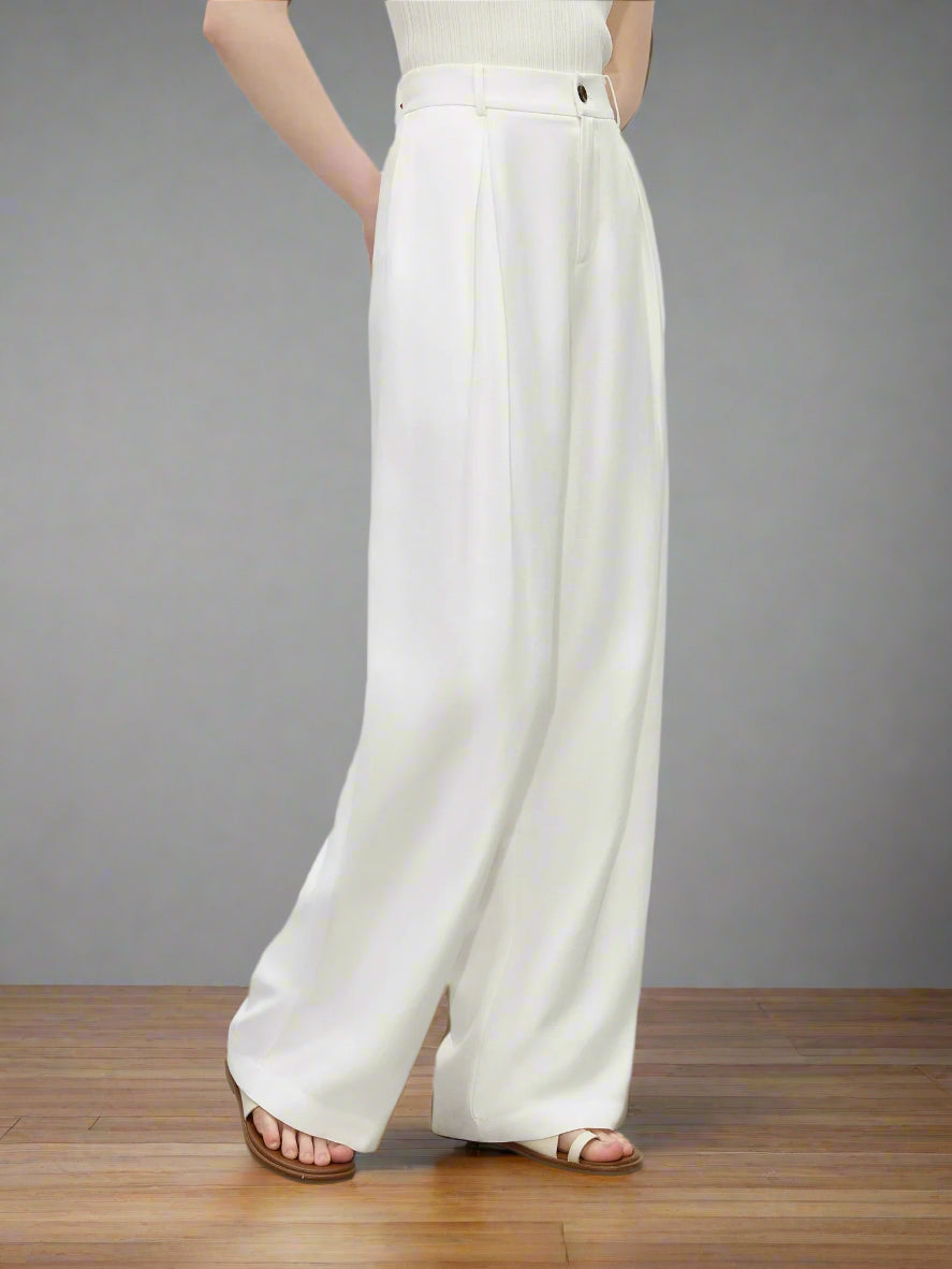 Person wearing white wide-leg pants on a plain background