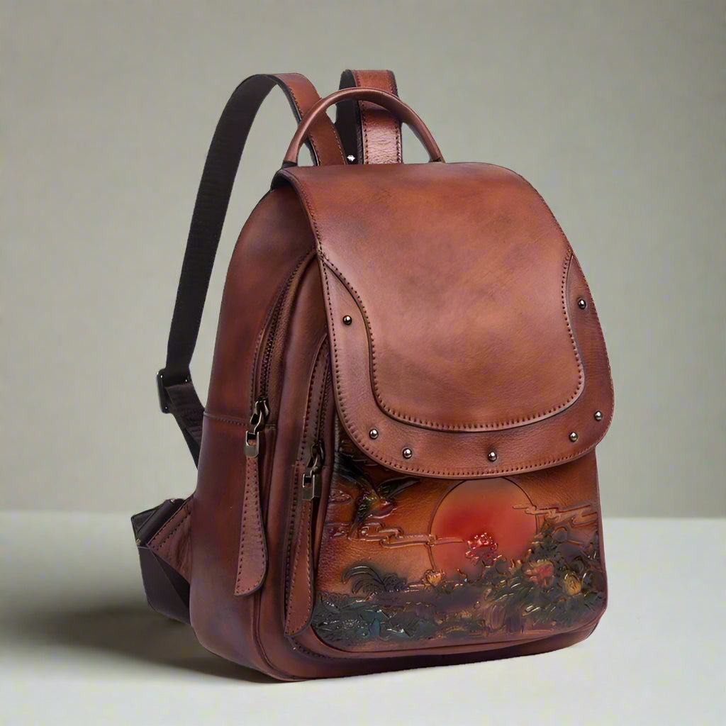 Brown leather backpack with scenic design on a white background