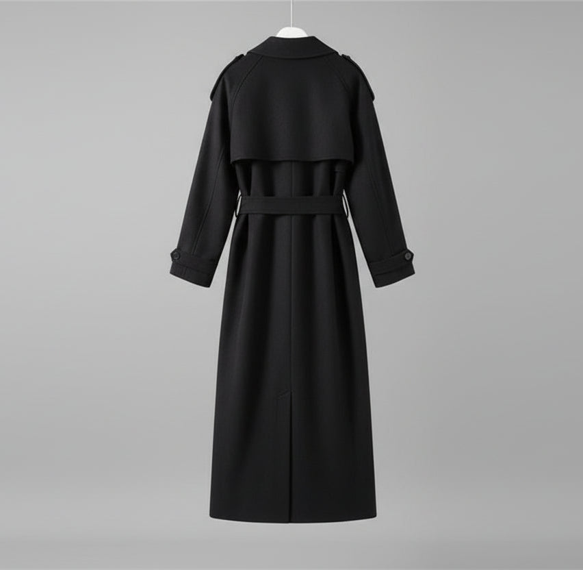 Black coat hanging against a neutral wall with minimal decor.