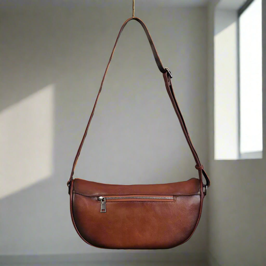 Brown leather shoulder bag on a a light background