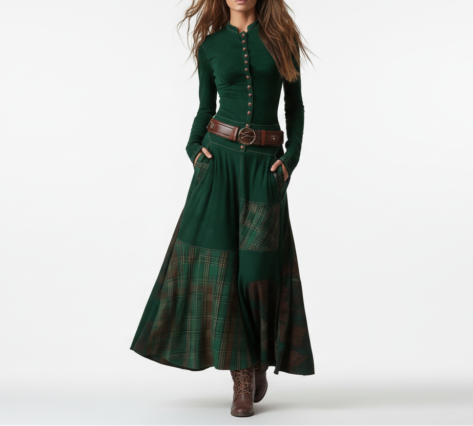 Woman wearing a long green dress with plaid pattern and brown belt against a gray background