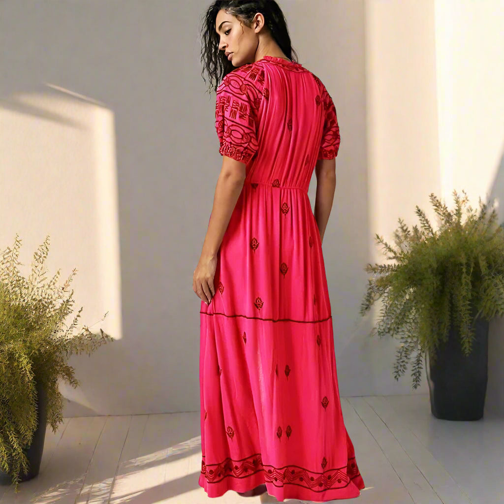 Woman wearing a red dress with black patterns on a white background