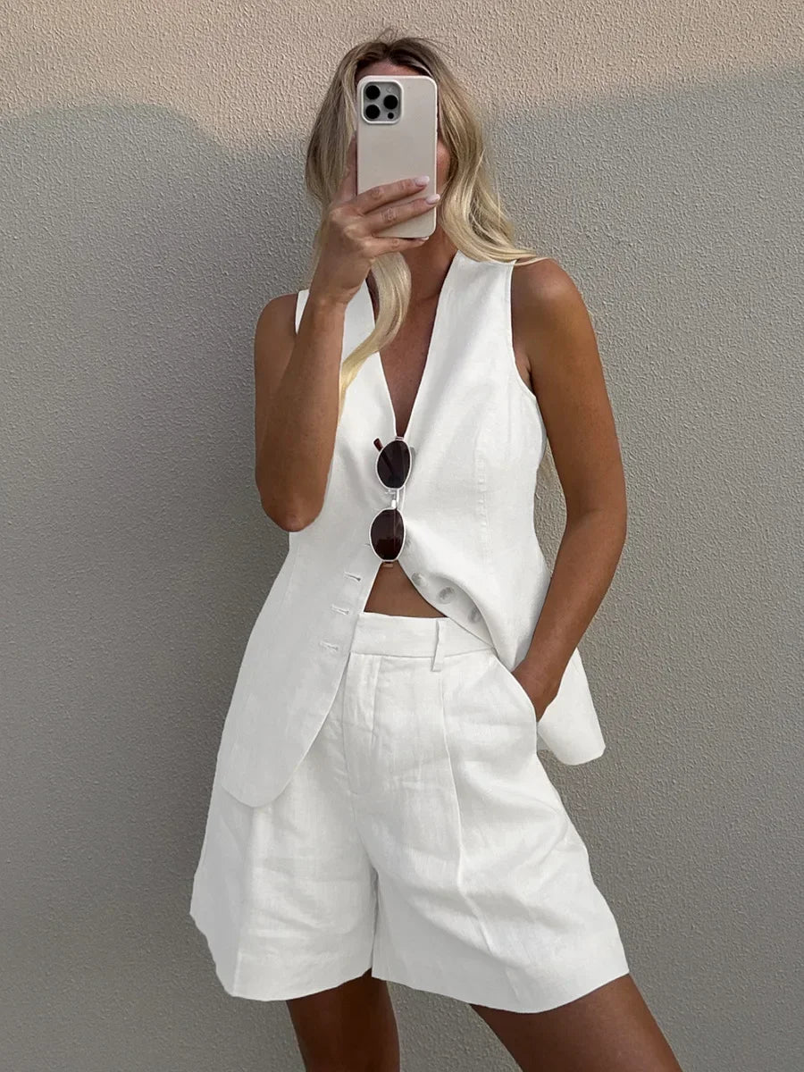 Person wearing a white outfit with a vest and shorts, taking a selfie.
