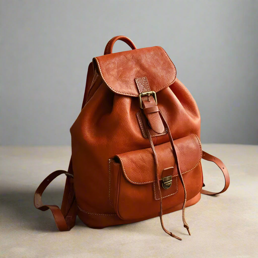 Brown leather backpack on a wooden surface with a neutral background