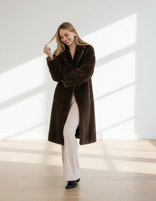 Woman wearing a brown faux fur coat against a white background