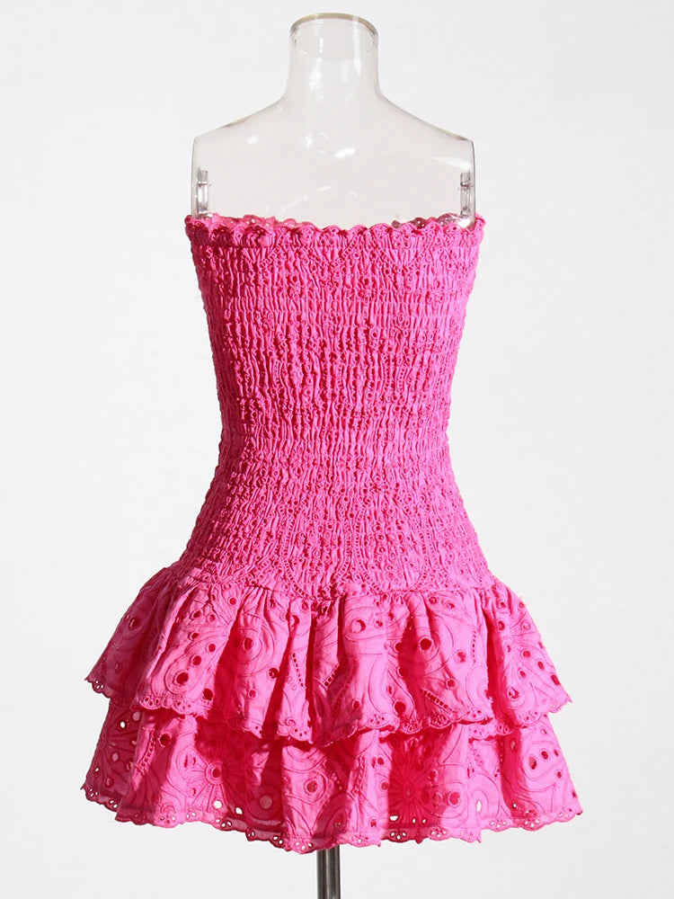 Pink strapless dress with ruffled layers on a mannequin against a white background