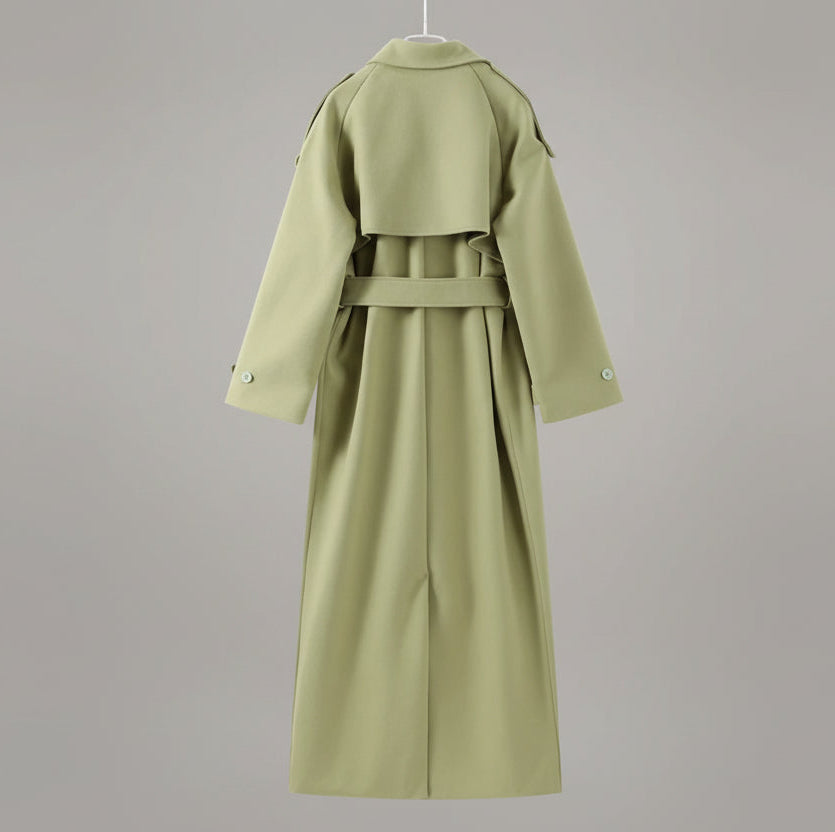 Light green trench coat on a hanger against a neutral background