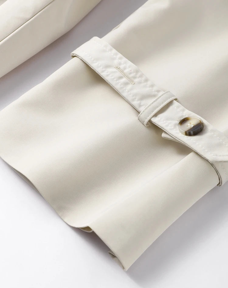 Close-up of a beige leather bag with a button on a light gray background