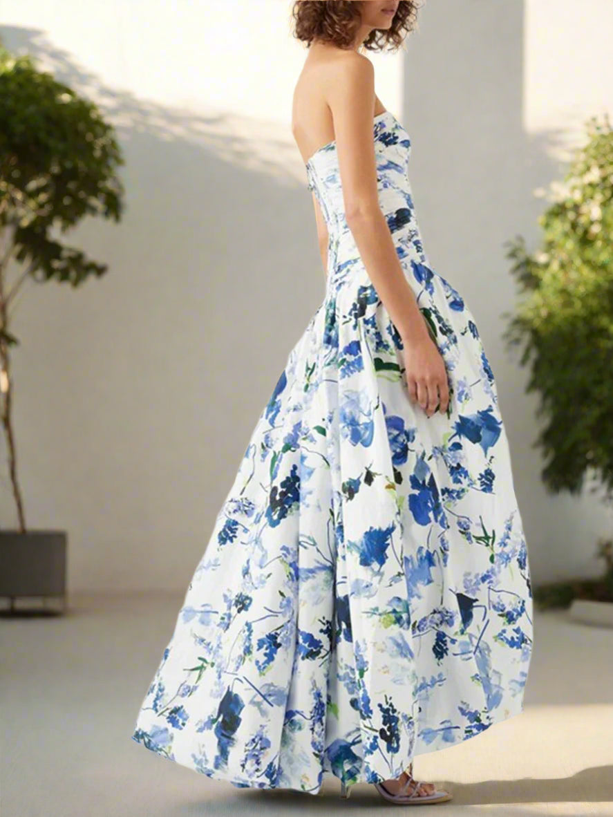 Woman wearing a strapless floral dress with blue and green patterns on a backyard garden, sunny day