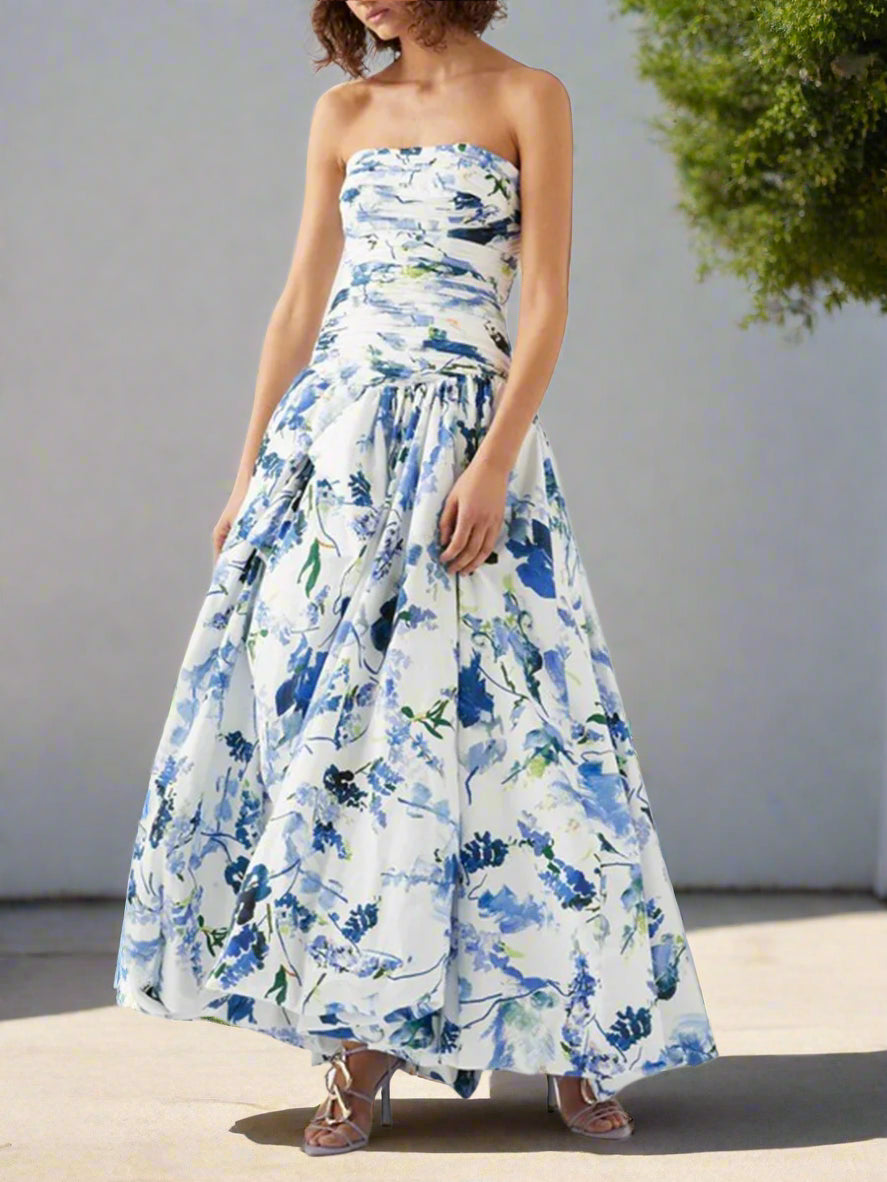 Woman wearing a strapless floral dress with blue and green patterns on a backyard garden, sunny day