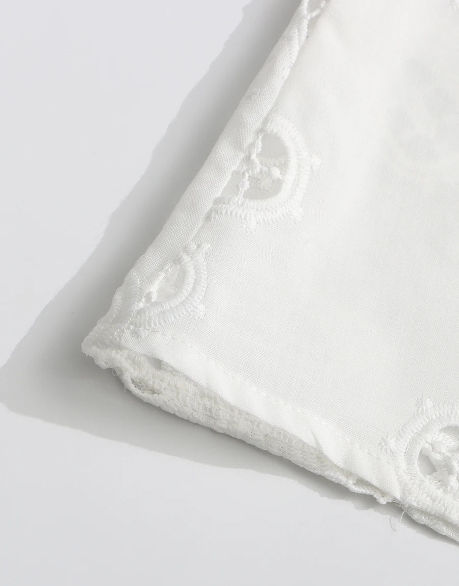 White fabric with lace detailing on a light gray background