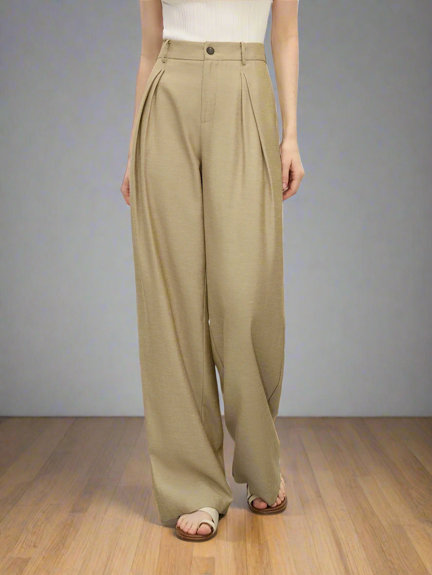 Person wearing beige wide-leg pants on a plain background