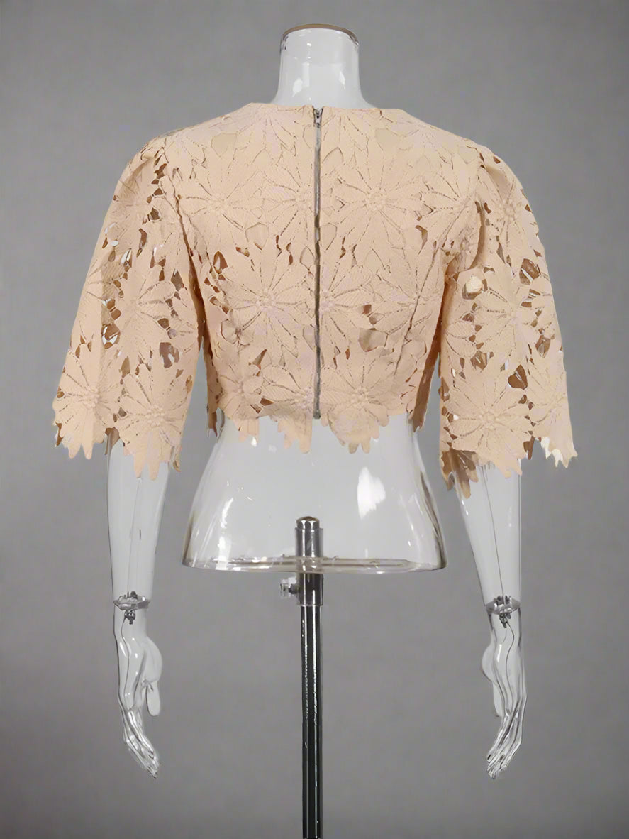 Beige lace shrug on a mannequin against a white background
