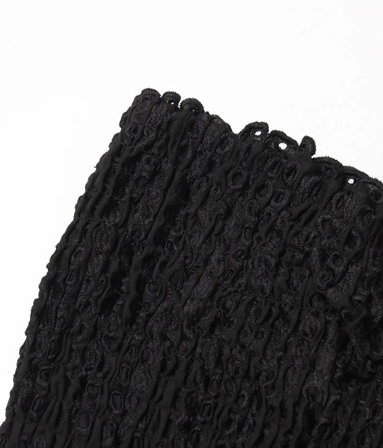 Close-up of a textured black fabric with a white background