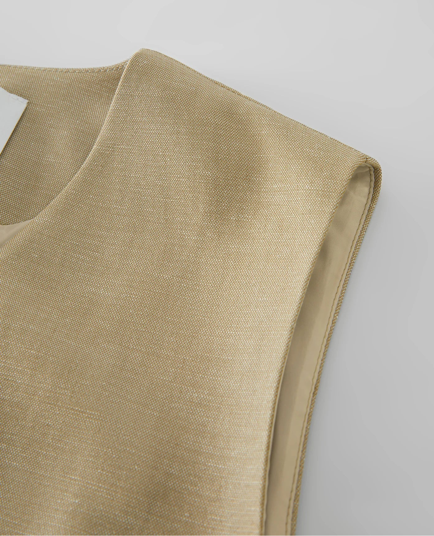 Beige sleeveless top on a light gray background