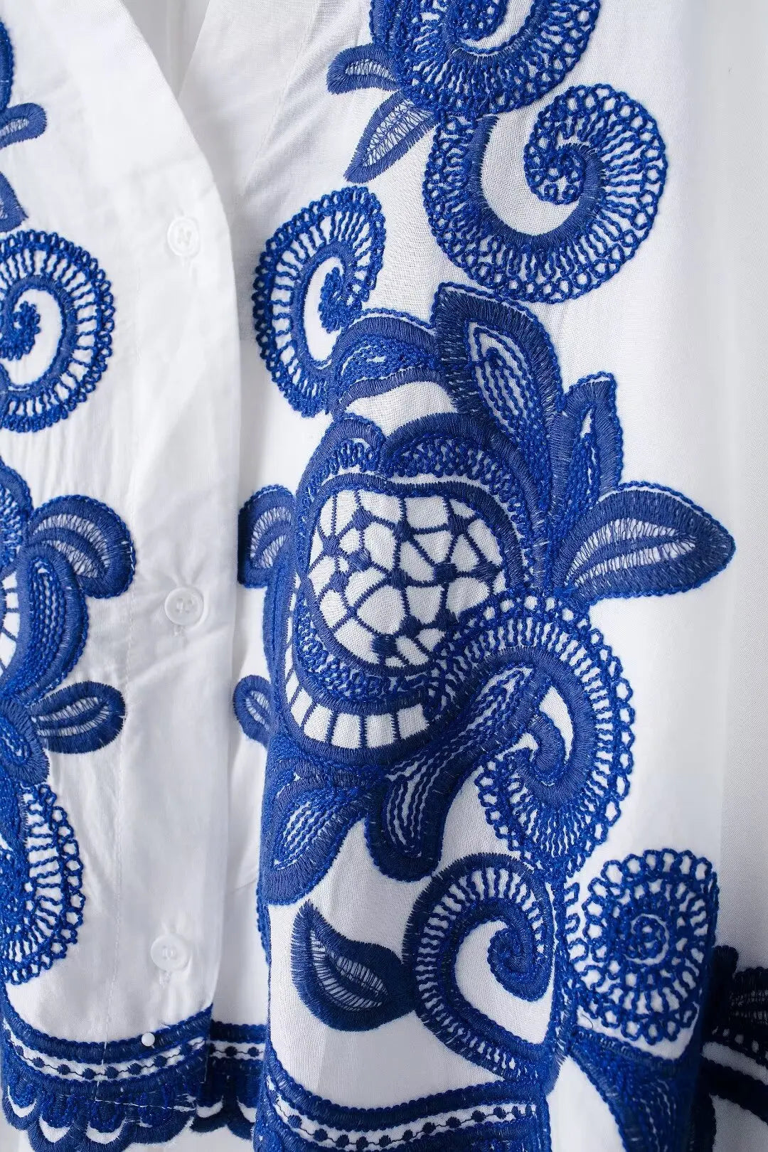 White fabric with intricate blue embroidery