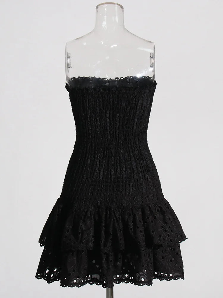 Black strapless dress with ruffled details on a mannequin against a white background