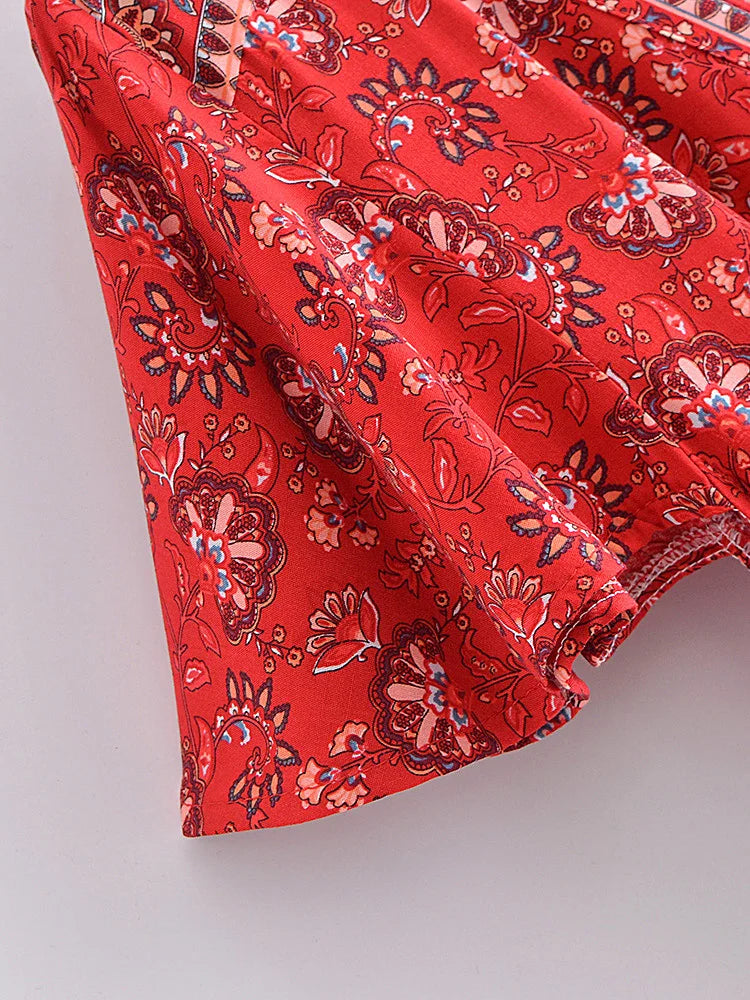 Red fabric with intricate floral pattern on a light gray background
