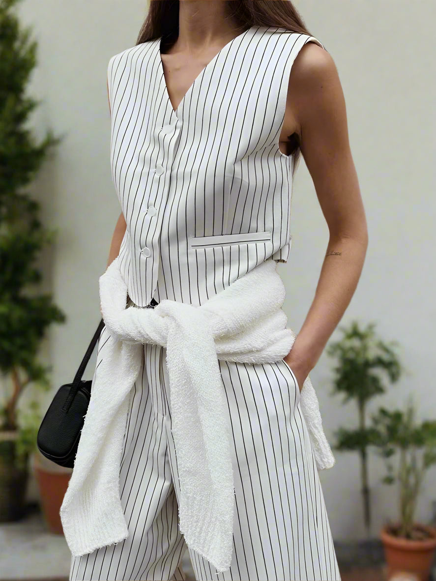 Woman wearing a white pinstripe outfit with a backyard garden, sunny