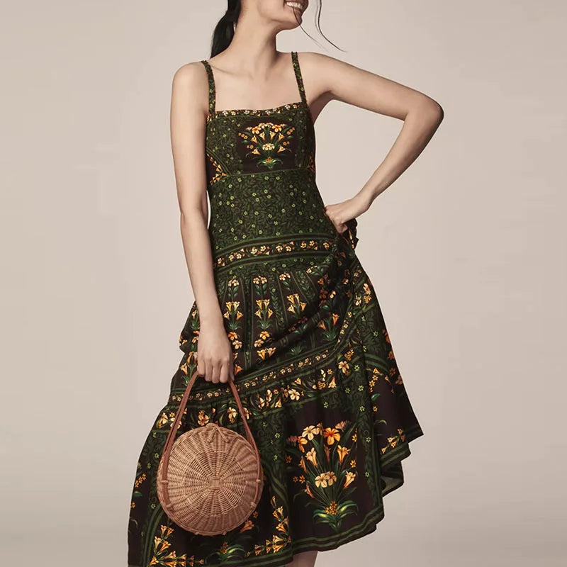 Woman wearing a dark green patterned dress holding a round woven bag against a beige background