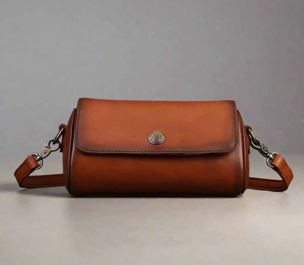 Brown leather handbag on a gray surface with a gray background