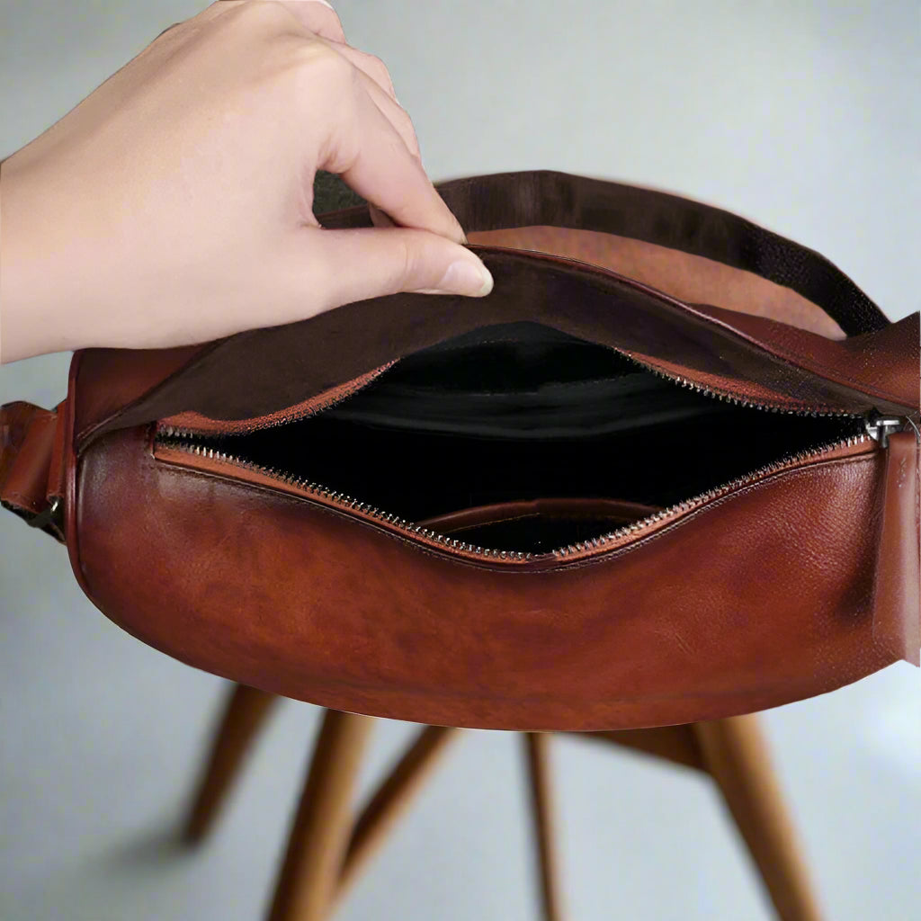 Brown leather bag on a wooden table and white floor